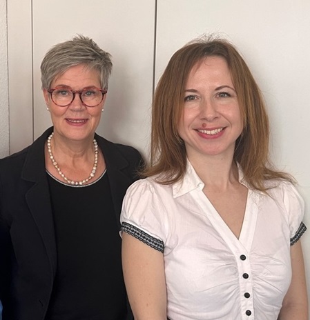 Foto mit 2 Frauen, die nebeneinander stehen.